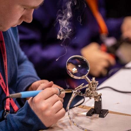 A USITT attendee works on a soldering project