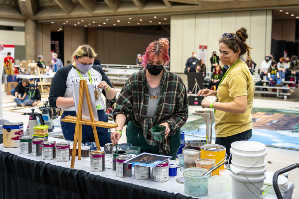 people painting at the paint lab in the lab space on the expo floor