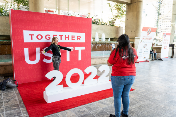 a person having their photo taken at the usitt 2022 step and repeat