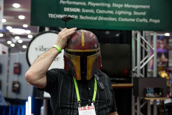 A person wearing a crafted helmet that goes over their entire head on the Expo floor