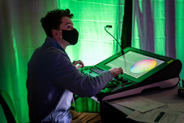 Person trying out a light board at a booth on the Expo floor