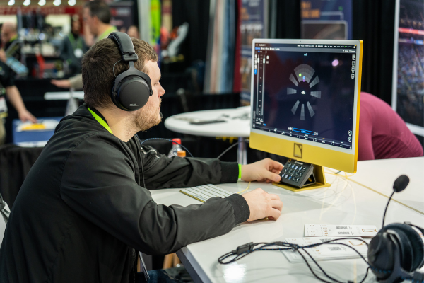 A person sitting at a computer trying out new technology on the Expo floor