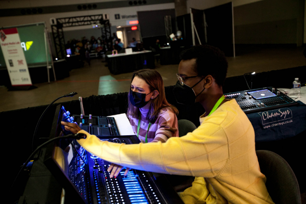 Two individuals on the expo floor trying out a Chamsys board