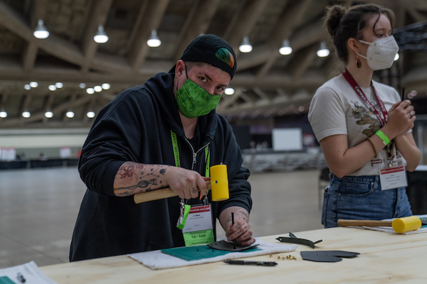 a person using a mallet and other material to nail something into the material during a hands on lab