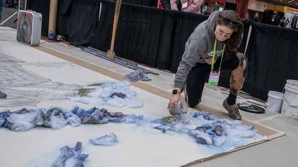 a person spreading sparkles onto a project at the paint lab