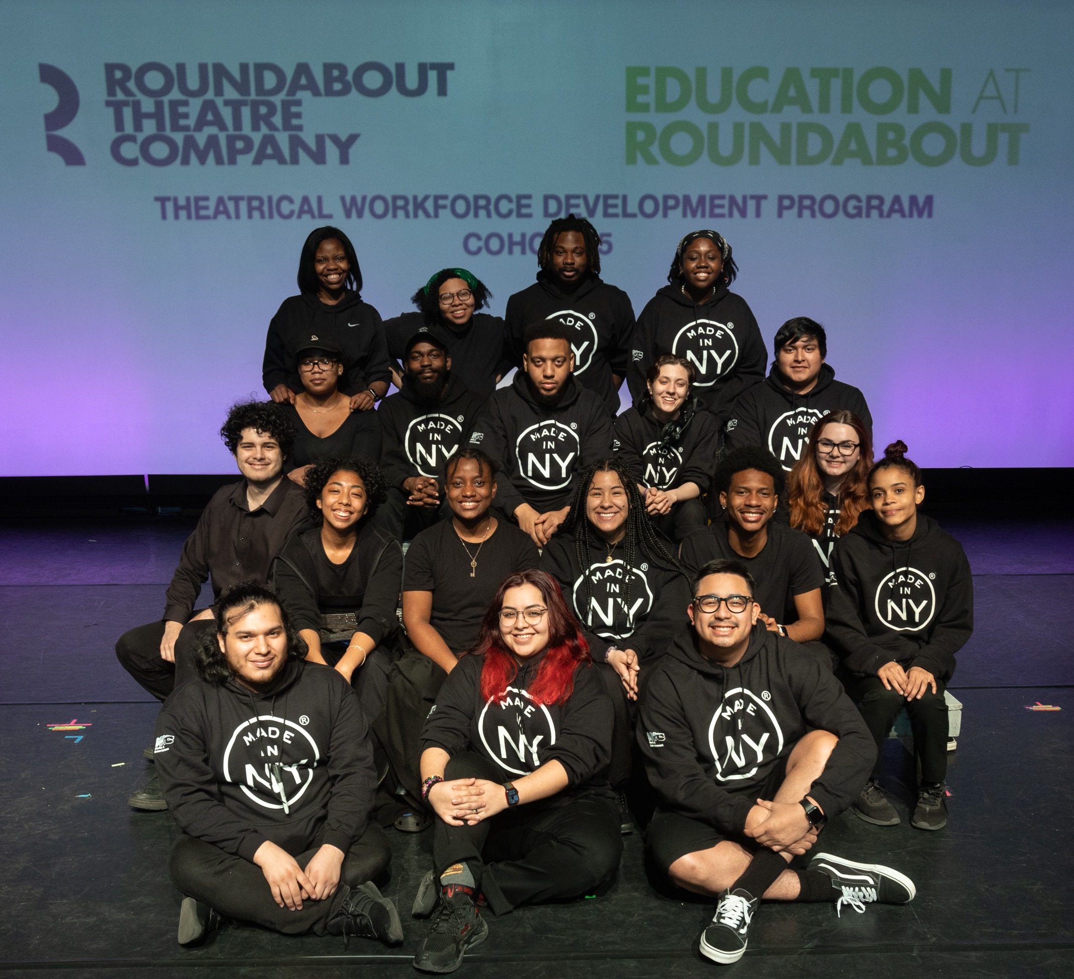 Group of people posing in front of Roundabout Step and Repeat