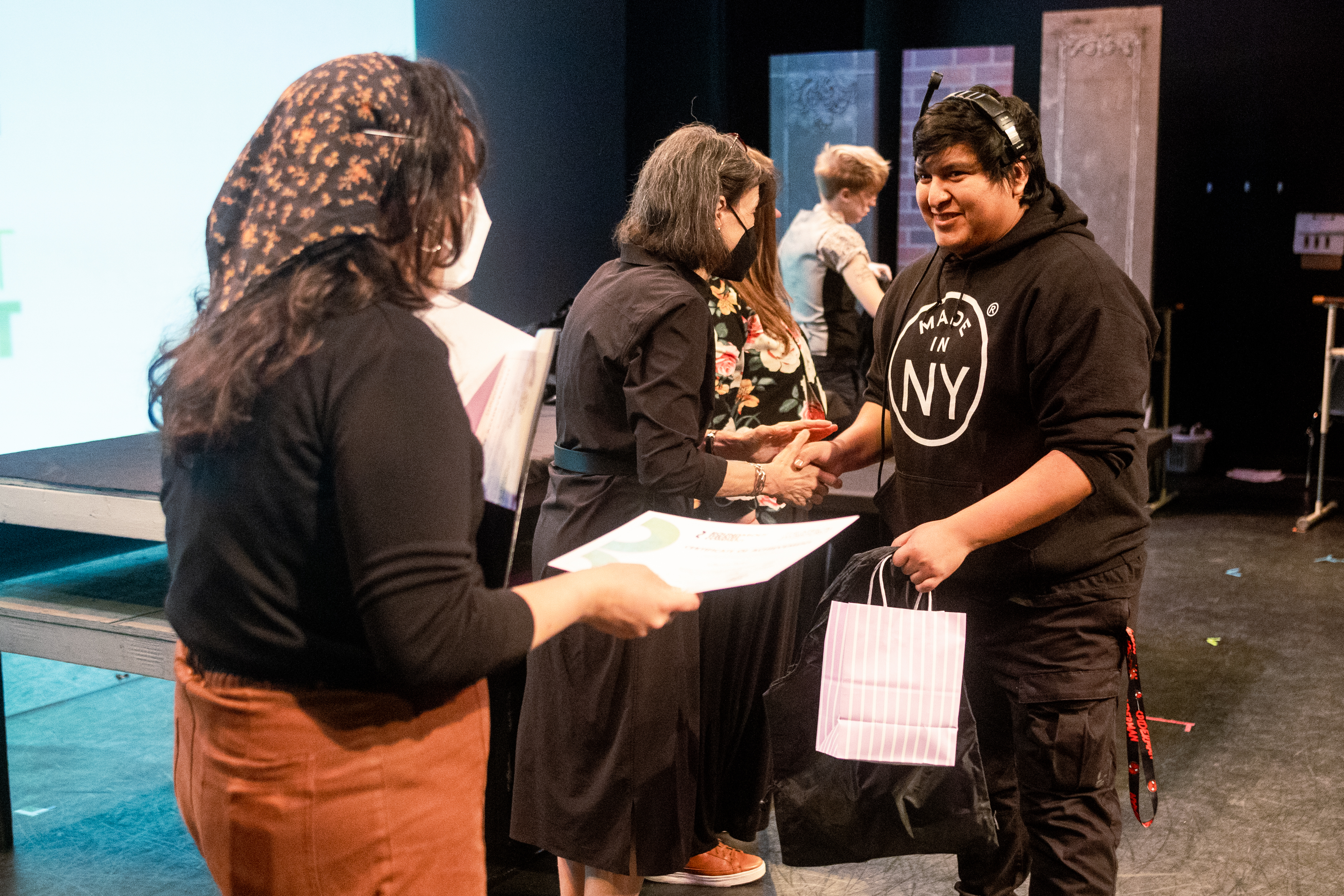 People on a stage shaking hands and chatting