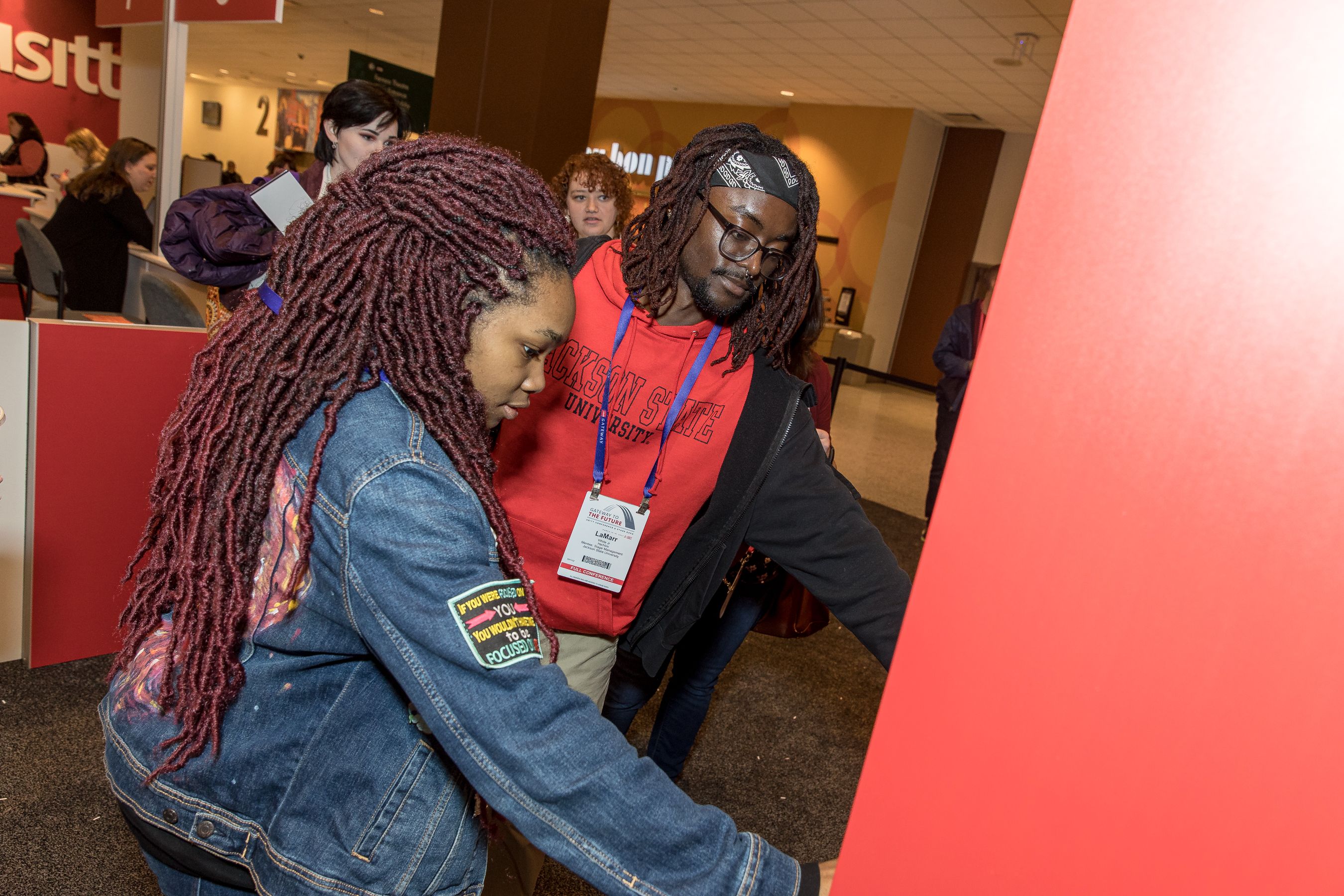 Two students looking at name badge ribbons at registration at USITT23 in St. Louis