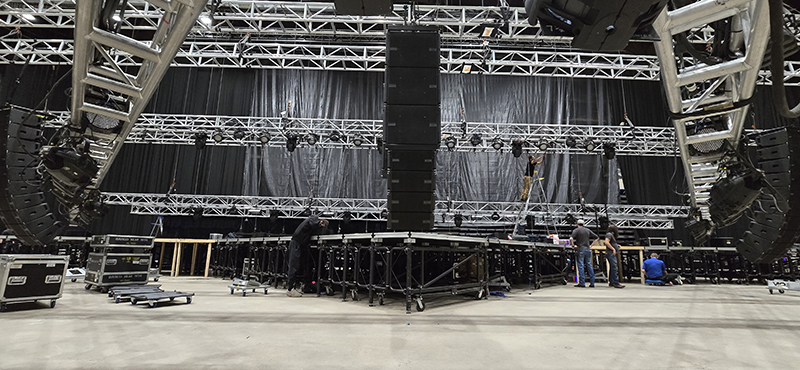 Arena with truss and speakers being loaded in.